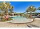 Beautiful zero entry pool with palm trees, colorful plants, and a shaded seating area, perfect for relaxation at 34084 Torrent Ln, Wesley Chapel, FL 33543