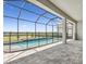 Screened in pool with a brick patio, and a view of the green space at 34084 Torrent Ln, Wesley Chapel, FL 33543