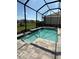 Inviting pool with stone accents inside screened enclosure and scenic backyard views at 34084 Torrent Ln, Wesley Chapel, FL 33543