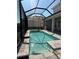 Sparkling pool with stone surround within screened enclosure offering a private outdoor space at 34084 Torrent Ln, Wesley Chapel, FL 33543