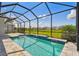 Sparkling pool in screened lanai offers a refreshing escape and serene backyard views at 34084 Torrent Ln, Wesley Chapel, FL 33543
