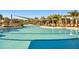 Large swimming pool with a shaded seating area, palm trees, and plenty of space for swimming and relaxing at 34084 Torrent Ln, Wesley Chapel, FL 33543