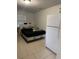 Bedroom with dark bed frame, large window, and white refrigerator at 3713 E Clifton St, Tampa, FL 33610