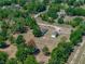 An aerial view of a sprawling home and detached garage, surrounded by lush greenery and mature trees at 38824 Raiser Rd, Dade City, FL 33525