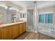 Bathroom featuring a jacuzzi tub, stand-up shower, double sinks and classic columns at 38824 Raiser Rd, Dade City, FL 33525