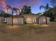 Elegant single-story home featuring double-door entry, arched windows, and lush palm trees at 38824 Raiser Rd, Dade City, FL 33525