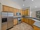 Bright kitchen featuring stainless steel appliances, tile floors, and wood cabinets at 38824 Raiser Rd, Dade City, FL 33525