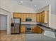 Well-equipped kitchen featuring stainless steel appliances, wooden cabinetry, and gray countertops at 38824 Raiser Rd, Dade City, FL 33525