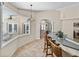 Open-concept kitchen with bar seating, tiled floors, and views of adjacent sunroom at 38824 Raiser Rd, Dade City, FL 33525
