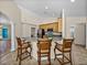 Contemporary kitchen with breakfast bar, tiled floor, and stainless steel appliances overlooking living area at 38824 Raiser Rd, Dade City, FL 33525