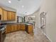 Open kitchen with wood cabinets, breakfast bar, and view into other living areas at 38824 Raiser Rd, Dade City, FL 33525