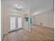 Bright living room featuring wood-look tile floors, elegant lighting, and an open floor plan at 38824 Raiser Rd, Dade City, FL 33525