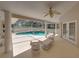 Covered patio with ceiling fan, white furniture, and views of the pool and backyard, perfect for relaxing at 38824 Raiser Rd, Dade City, FL 33525