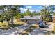 Angle view of brick home with a long driveway, cars parked outside and lawn at 4085 37Th N Ave, St Petersburg, FL 33713