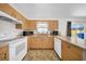 A kitchen featuring light wood cabinets, a white range, and a window over the sink at 4085 37Th N Ave, St Petersburg, FL 33713