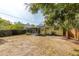 Backyard featuring a screened in patio, solar panels, and mature landscaping at 4517 2Nd S Ave, St Petersburg, FL 33711