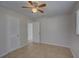 Neutral-toned bedroom with tile flooring, ceiling fan, and white paneled doors for a clean, modern aesthetic at 4517 2Nd S Ave, St Petersburg, FL 33711