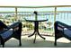 Inviting balcony view with wicker chairs and a table, offering a picturesque scene of waterfront homes and the bay at 4900 Brittany S Dr # 1810, St Petersburg, FL 33715