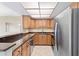 A kitchen featuring wooden cabinets, dark countertops, stainless steel appliances, and tile flooring at 4900 Brittany S Dr # 1810, St Petersburg, FL 33715