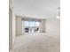 A living room with carpet flooring, a sliding glass door to a balcony with a view of the water at 4900 Brittany S Dr # 1810, St Petersburg, FL 33715