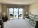 A bright living room with carpet, a sofa, and sliding doors leading to a balcony with a water view at 4900 Brittany S Dr # 1810, St Petersburg, FL 33715