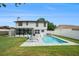 Expansive backyard featuring a sparkling pool, lounge chairs, lush lawn, and outdoor dining area at 4914 Country Hills Dr, Tampa, FL 33624