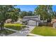 Charming home with a well-manicured front yard, a paved driveway, and a two-car garage at 4914 Country Hills Dr, Tampa, FL 33624