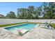 Relaxing pool area with a sun lounger, pristine water, stylish patio, and privacy fence at 4914 Country Hills Dr, Tampa, FL 33624