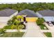 Aerial view of a yellow single-Gathering home with a two-car garage and lush, mature landscaping at 5048 Inshore Landing Dr, Apollo Beach, FL 33572