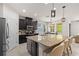 Open kitchen featuring dark wood cabinets, granite countertops, a large island, and stainless appliances at 5048 Inshore Landing Dr, Apollo Beach, FL 33572