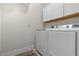 Laundry area with white washer and dryer, plus overhead white cabinets at 5048 Inshore Landing Dr, Apollo Beach, FL 33572