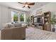 Cozy living room featuring large windows, a plush sofa, and a stylish entertainment center at 5048 Inshore Landing Dr, Apollo Beach, FL 33572