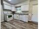 Practical kitchen featuring white appliances, ample counter space, and vinyl plank flooring at 5660 86Th Ave, Pinellas Park, FL 33782