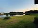 Serene backyard view with lush green lawn and peaceful lake at sunset offering a private oasis at 5670 Shorebird Br, Land O Lakes, FL 34638