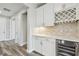 Chic bar area with wine storage, white cabinets, tile backsplash, and a wine cooler at 5670 Shorebird Br, Land O Lakes, FL 34638