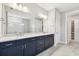 Elegant bathroom featuring a double vanity with dark cabinets and granite countertops at 5670 Shorebird Br, Land O Lakes, FL 34638