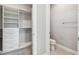 Bright bathroom with modern toilet and adjacent walk-in closet featuring custom shelving at 5670 Shorebird Br, Land O Lakes, FL 34638