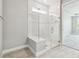 Modern bathroom featuring a glass-enclosed shower with tiled walls and a built-in seat at 5670 Shorebird Br, Land O Lakes, FL 34638