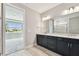 Elegant bathroom featuring a double vanity with dark cabinets and granite countertops at 5670 Shorebird Br, Land O Lakes, FL 34638