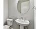 Elegant bathroom featuring a pedestal sink, oval mirror, and modern fixtures at 5670 Shorebird Br, Land O Lakes, FL 34638
