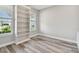 Bedroom features wood-look flooring, a built-in bookcase, and two bright windows at 5670 Shorebird Br, Land O Lakes, FL 34638