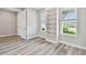 Bedroom with wood-look flooring, two windows, and a built-in bookshelf at 5670 Shorebird Br, Land O Lakes, FL 34638