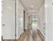 Bright entryway with wood-look floors, white trim and doors, offers a welcoming view into the spacious open-concept living area at 5670 Shorebird Br, Land O Lakes, FL 34638