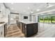 Open-concept kitchen with a center island flowing into a living area with large windows and a view to the outdoors at 5670 Shorebird Br, Land O Lakes, FL 34638