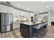 Bright kitchen features white cabinets, stainless steel appliances, and a large center island with barstool seating at 5670 Shorebird Br, Land O Lakes, FL 34638