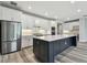 Modern kitchen boasts white cabinets, stainless steel appliances, a spacious center island, and stylish pendant lighting at 5670 Shorebird Br, Land O Lakes, FL 34638