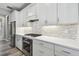 Well-lit kitchen featuring stainless steel appliances, white cabinets, and a tile backsplash at 5670 Shorebird Br, Land O Lakes, FL 34638