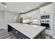 Modern kitchen boasts white cabinets, a spacious center island, stainless steel appliances, and elegant countertops at 5670 Shorebird Br, Land O Lakes, FL 34638