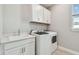 Well-lit laundry room features modern appliances, white cabinetry, and a quartz countertop at 5670 Shorebird Br, Land O Lakes, FL 34638