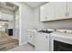 Bright laundry room with washer and dryer, white cabinets and wood-look floors at 5670 Shorebird Br, Land O Lakes, FL 34638